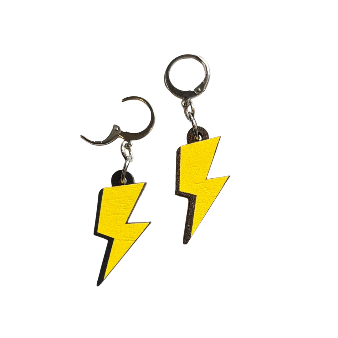 A photograph of two lightning bolt shaped dangle earrings connected to a small huggie hoop on a white background.