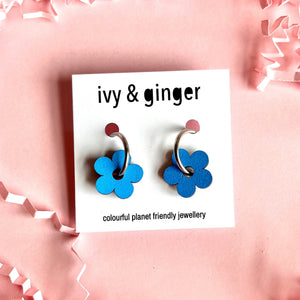 hand painted blue wooden flower hoop earrings on a pink background