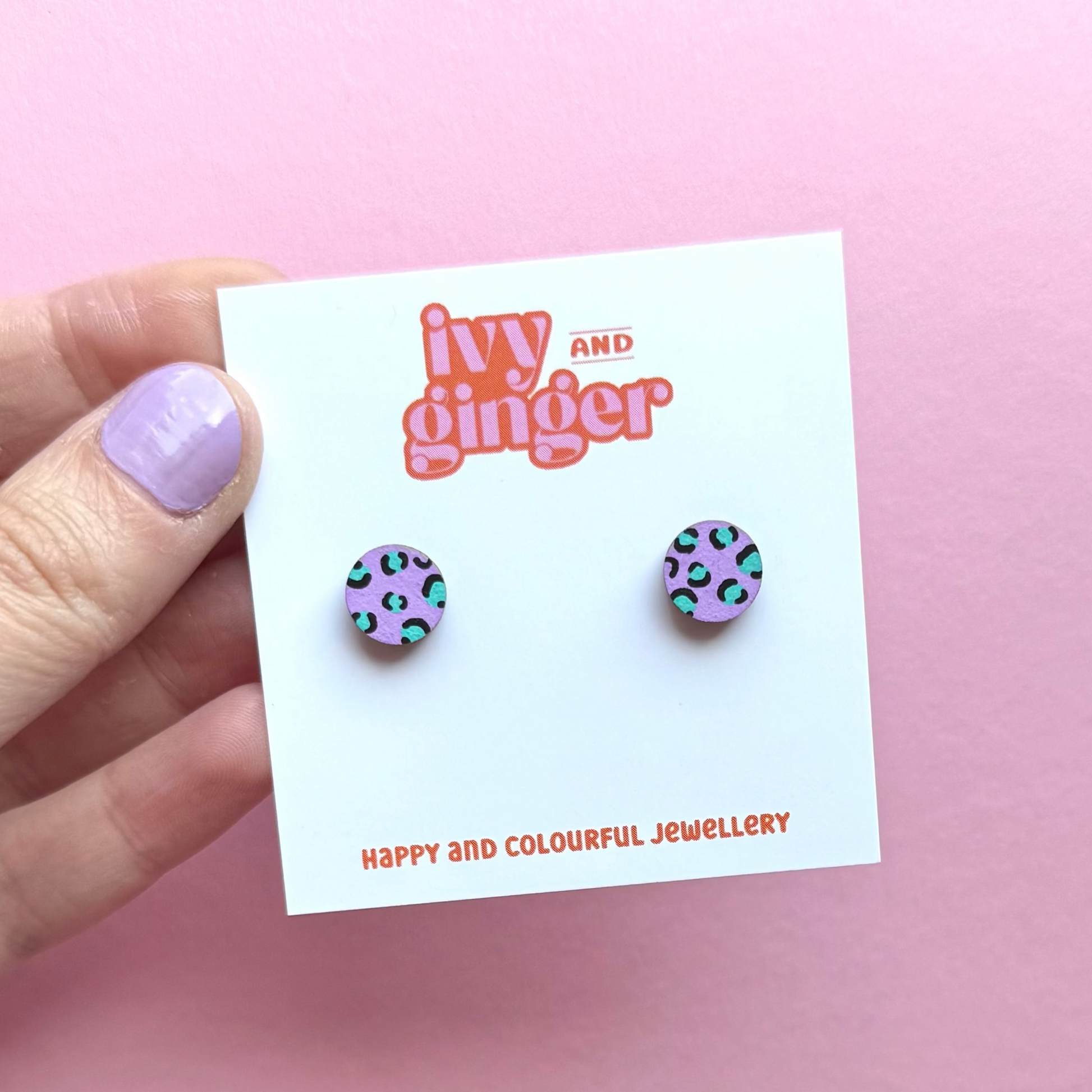 Pair of earrings on a 'Ivy and Ginger' branded card against a pink background