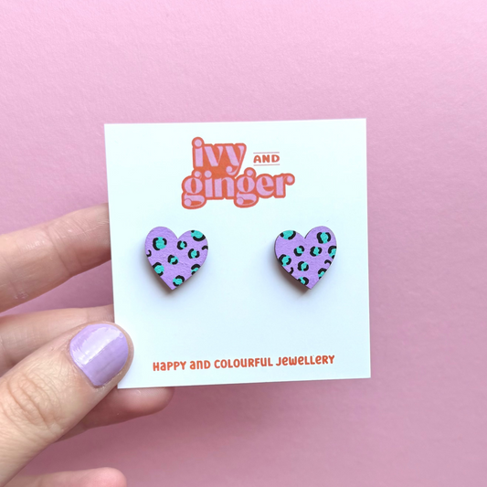 Heart-shaped earrings on a 'Ivy and Ginger' branded card against a pink background