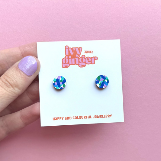 Colorful earrings on a 'Ivy and Ginger' branded card against a pink background