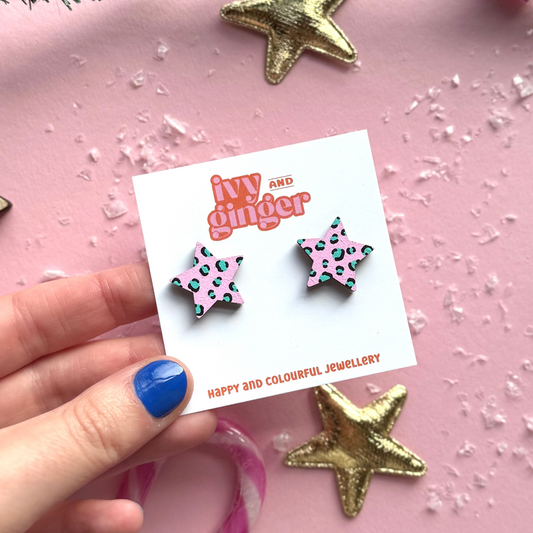Star-shaped earrings on a 'ivy and ginger' card with decorative stars on a pink background