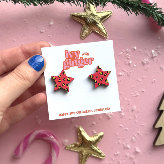 Star-shaped earrings held on a card with 'Ivy and Ginger' branding against a festive background.